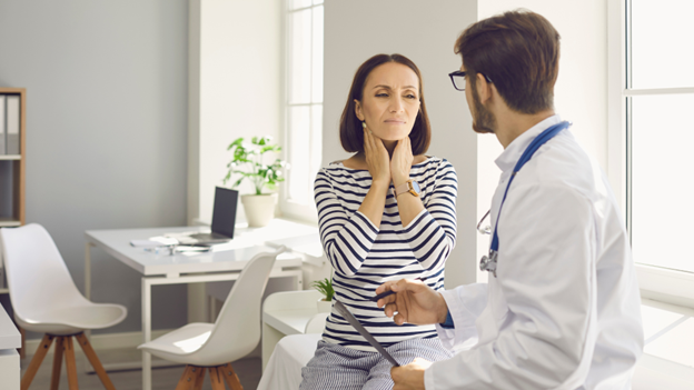 Woman sitting with a provider experiencing strep throat symptoms in need of rapid strep tests