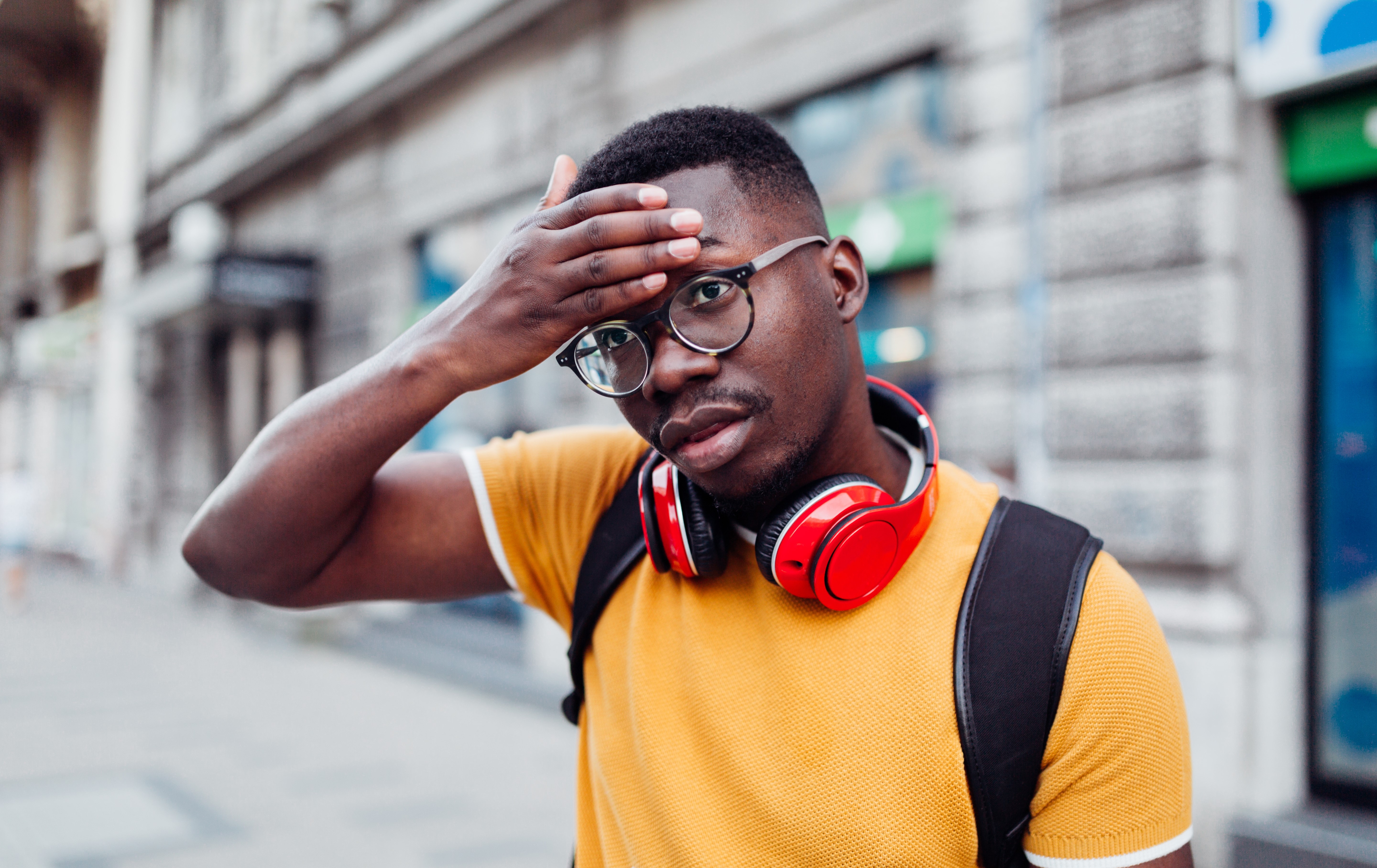 Young man in the street feeling feverish