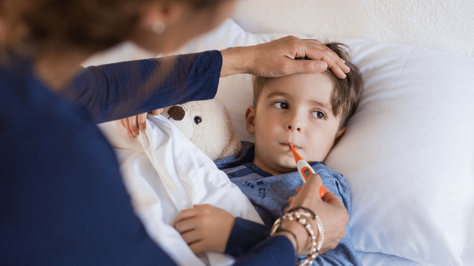 Mother checking a young boy's fever with a thermometer, focusing on managing high fevers in children