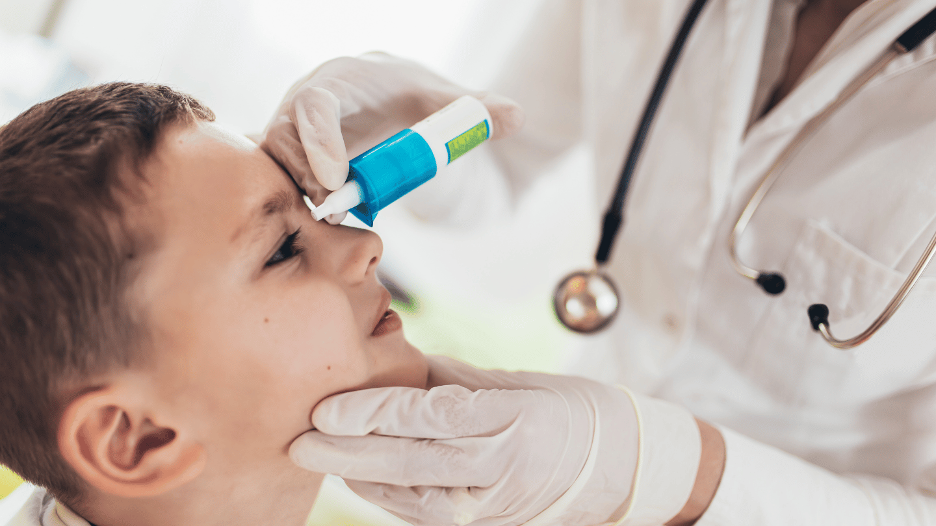 CityMD doctor applying eye drops to a child for pink eye treatment