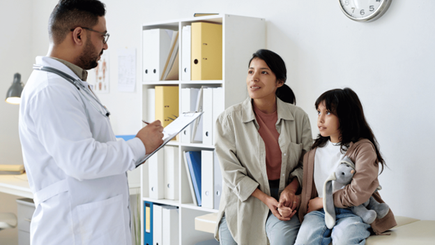 A CityMD urgent care doctor consulting with a mother and her young child holding a stuffed bunny during an urgent care visit